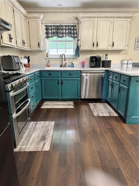 20796 Dawn Hill E Rd, Gentry, AR 72734 - kitchen featuring appliances with stainless steel finishes, dark wood-type flooring, light countertops, exhaust hood, and ornamental molding