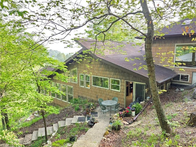 1655 Wilson Springs Rd, Harrison, AR 72601 - back of house featuring roof with shingles, a patio area, and a sunroom