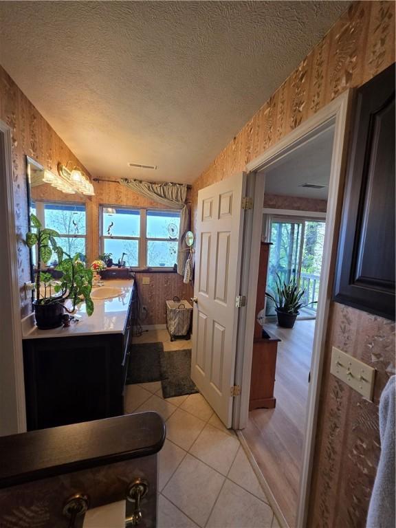 1655 Wilson Springs Rd, Harrison, AR 72601 - bathroom with wood walls, wallpapered walls, vanity, a textured ceiling, and tile patterned flooring