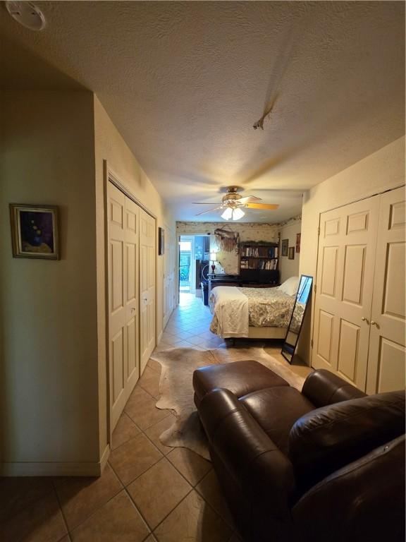 1655 Wilson Springs Rd, Harrison, AR 72601 - bedroom featuring light tile patterned flooring, a textured ceiling, ceiling fan, and a closet