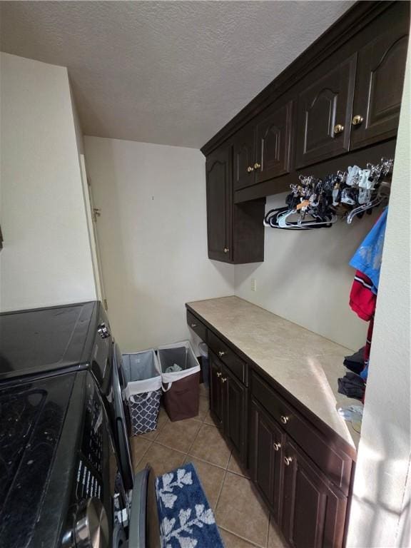 1655 Wilson Springs Rd, Harrison, AR 72601 - washroom with light tile patterned floors, a textured ceiling, cabinet space, and washer and dryer
