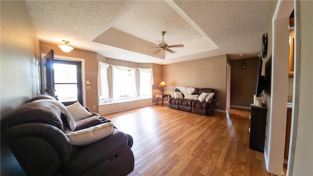 5 Coatbridge Ln, Bella Vista, AR 72715 - living area featuring a textured ceiling, a tray ceiling, wood finished floors, and ceiling fan