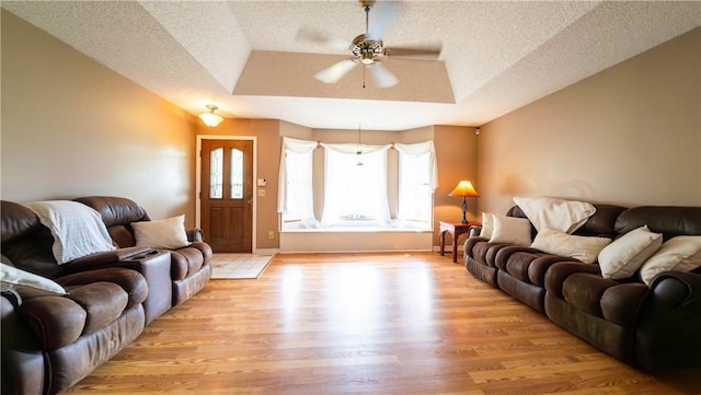5 Coatbridge Ln, Bella Vista, AR 72715 - living area with a textured ceiling, light wood-style floors, a ceiling fan, and a raised ceiling