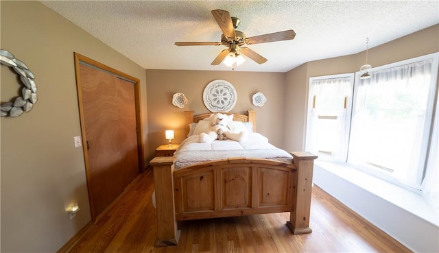 5 Coatbridge Ln, Bella Vista, AR 72715 - bedroom with wood finished floors, a textured ceiling, a closet, and a ceiling fan