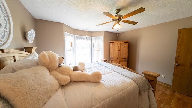 5 Coatbridge Ln, Bella Vista, AR 72715 - bedroom featuring wood finished floors, ceiling fan, and a textured ceiling