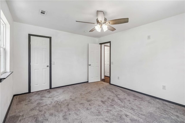17707 12th Hwy, Rogers, AR 72756 - unfurnished bedroom with carpet floors, multiple windows, and ceiling fan