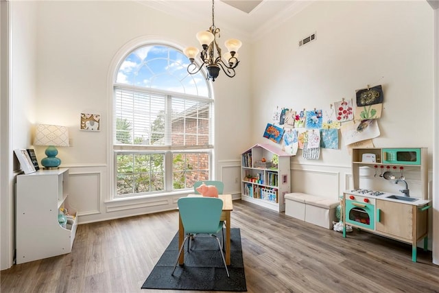 793 Buckhead Ave, Springdale, AR 72764 - game room featuring a decorative wall, a chandelier, plenty of natural light, wood finished floors, and a wainscoted wall