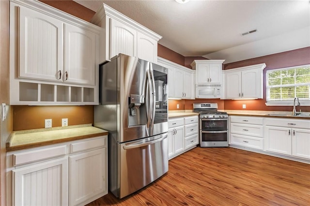 22006 Bozarth Cemetery Rd, Gentry, AR 72734 - kitchen featuring stainless steel appliances, white cabinetry, light countertops, and light wood-style flooring
