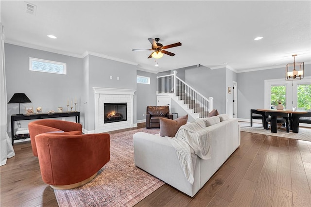 3205 Summer View Ave, Springdale, AR 72764 - living room featuring stairway, healthy amount of natural light, hardwood / wood-style floors, a brick fireplace, and crown molding