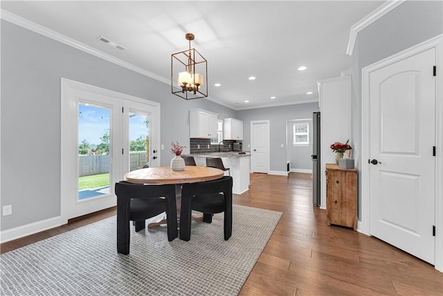 3205 Summer View Ave, Springdale, AR 72764 - dining room with healthy amount of natural light, a chandelier, ornamental molding, dark wood finished floors, and recessed lighting