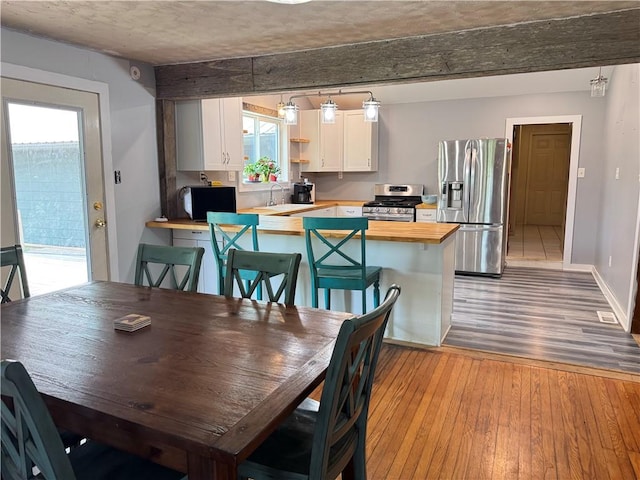 7792 Bubbling Springs Rd, Harrison, AR 72601 - dining space with wood finished floors and beamed ceiling