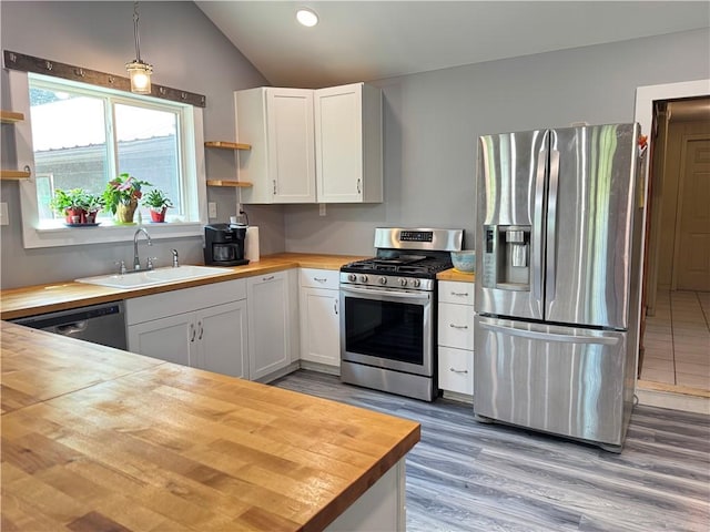 7792 Bubbling Springs Rd, Harrison, AR 72601 - kitchen featuring wooden counters, stainless steel appliances, open shelves, vaulted ceiling, and white cabinetry
