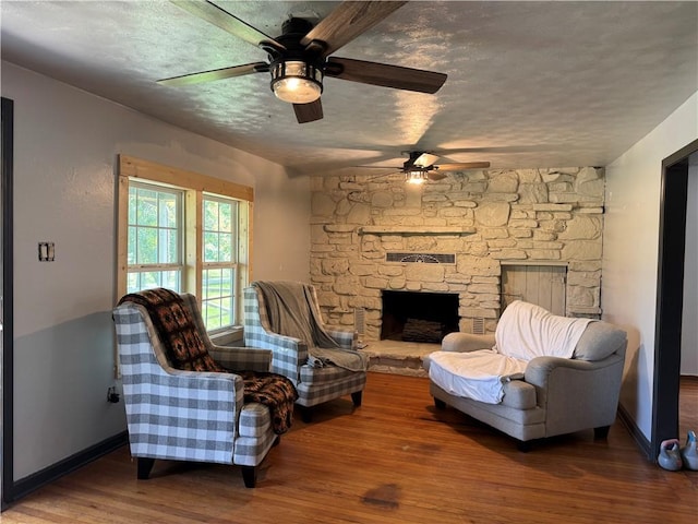 7792 Bubbling Springs Rd, Harrison, AR 72601 - living area with ceiling fan, wood finished floors, a textured ceiling, and a fireplace