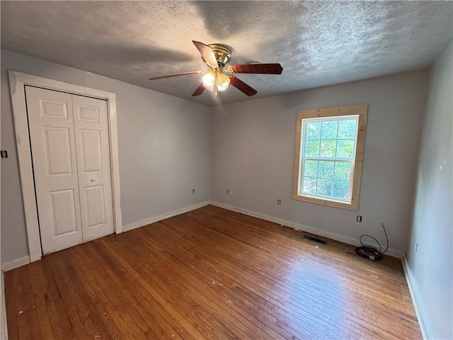 7792 Bubbling Springs Rd, Harrison, AR 72601 - unfurnished bedroom featuring hardwood / wood-style floors, a textured ceiling, a ceiling fan, and a closet