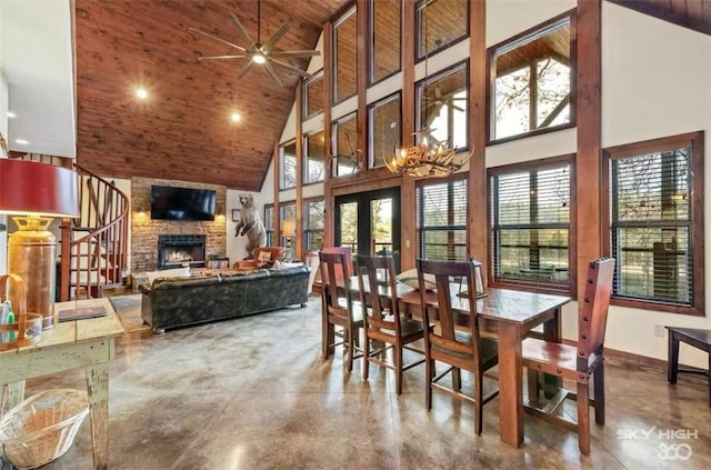 8715 Rambo N Rd, Rogers, AR 72756 - dining area with high vaulted ceiling, finished concrete floors, a fireplace, wood ceiling, and a ceiling fan
