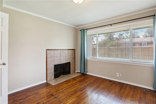 520 S 13th St, Rogers, AR 72758 - unfurnished living room featuring wood finished floors, healthy amount of natural light, a tiled fireplace, and crown molding