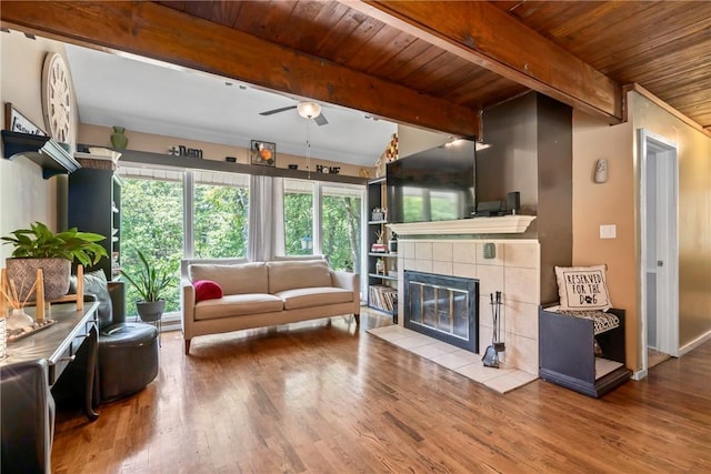 14269 Lake Forrest Heights Rd, Siloam Springs, AR 72761 - living room featuring a wooden ceiling with exposed beams, wood finished floors, ceiling fan, and a tiled fireplace