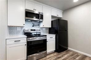 26 Norwood Dr, Bella Vista, AR 72714 - kitchen featuring appliances with stainless steel finishes, light countertops, white cabinetry, tasteful backsplash, and recessed lighting