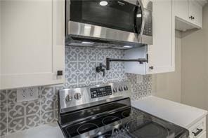 26 Norwood Dr, Bella Vista, AR 72714 - kitchen with stainless steel appliances, white cabinets, backsplash, and light countertops