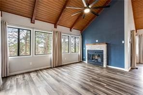 26 Norwood Dr, Bella Vista, AR 72714 - unfurnished living room with ceiling fan, a wood ceiling with exposed beams, a glass covered fireplace, wood finished floors, and high vaulted ceiling
