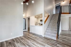 26 Norwood Dr, Bella Vista, AR 72714 - unfurnished living room with stairs, wood finished floors, and a towering ceiling
