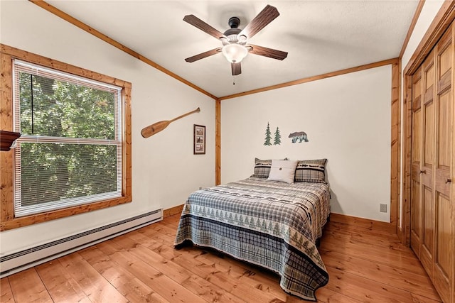 8092 Fain Dr, Rogers, AR 72756 - bedroom featuring a baseboard radiator, light wood-style flooring, crown molding, a closet, and a ceiling fan