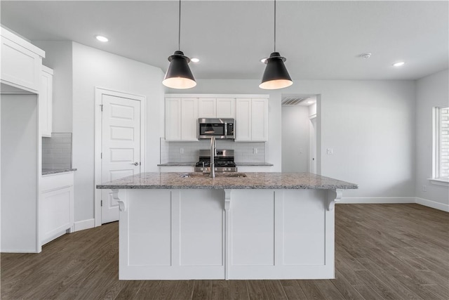 4669 W Triangle St, Fayetteville, AR 72704 - kitchen with stainless steel appliances, tasteful backsplash, white cabinetry, light stone counters, and recessed lighting