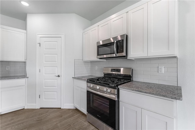 4669 W Triangle St, Fayetteville, AR 72704 - kitchen with stainless steel appliances, decorative backsplash, white cabinetry, wood finished floors, and light stone countertops