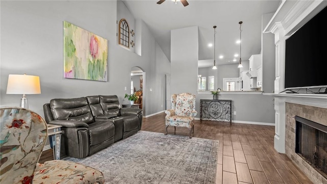 1705 Tull Dr, Pea Ridge, AR 72751 - living area with a fireplace, ceiling fan, a high ceiling, wood finished floors, and arched walkways