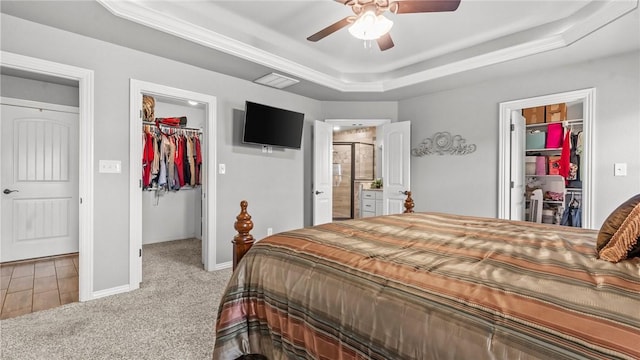1705 Tull Dr, Pea Ridge, AR 72751 - carpeted bedroom with a spacious closet, a tray ceiling, a closet, a ceiling fan, and connected bathroom