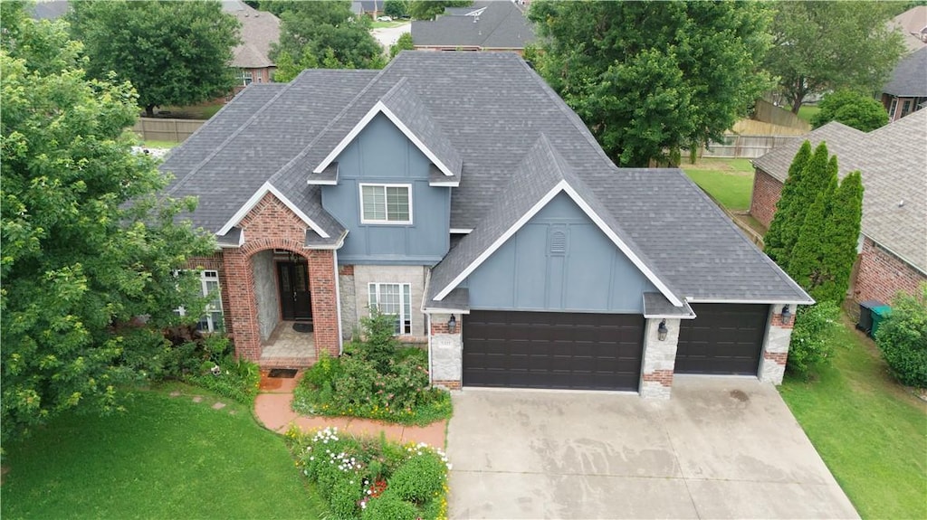5411 S Bent Tree Dr, Rogers, AR 72758 - view of front facade featuring roof with shingles, board and batten siding, a garage, a front yard, and brick siding