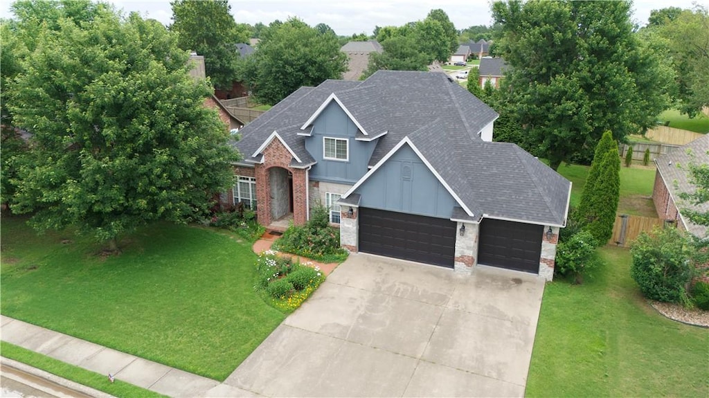 5411 S Bent Tree Dr, Rogers, AR 72758 - traditional home with an attached garage, board and batten siding, roof with shingles, driveway, and brick siding
