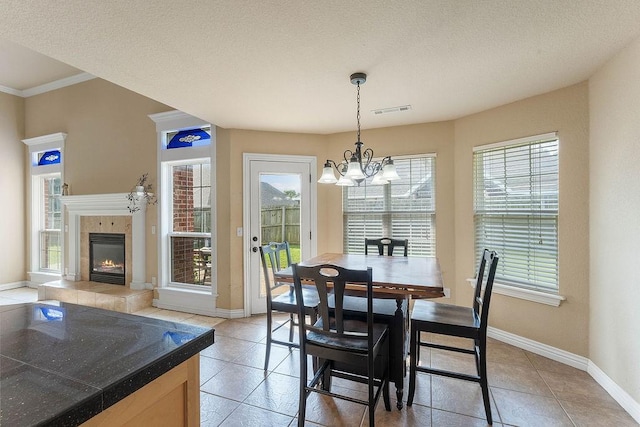 1315 S Breckenridge Loop, Rogers, AR 72756 - dining space featuring a chandelier, light tile patterned flooring, a tile fireplace, and crown molding