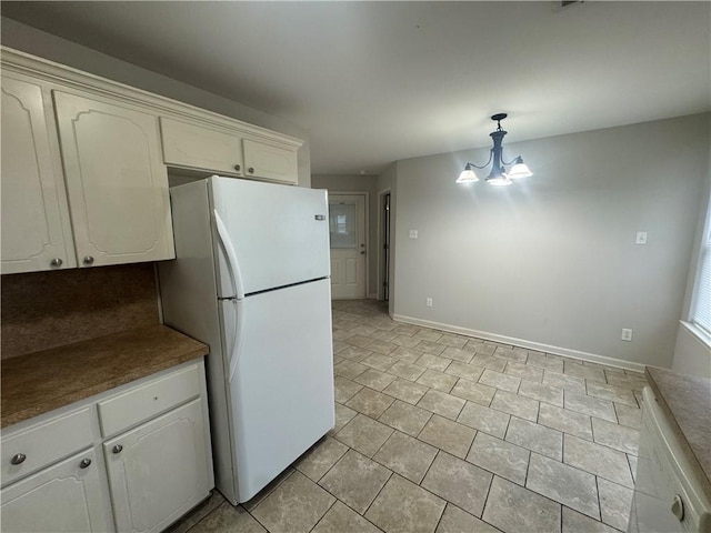 1010 Tori Ln, Beebe, AR 72012 - kitchen featuring freestanding refrigerator, a chandelier, white cabinetry, hanging light fixtures, and light tile patterned floors