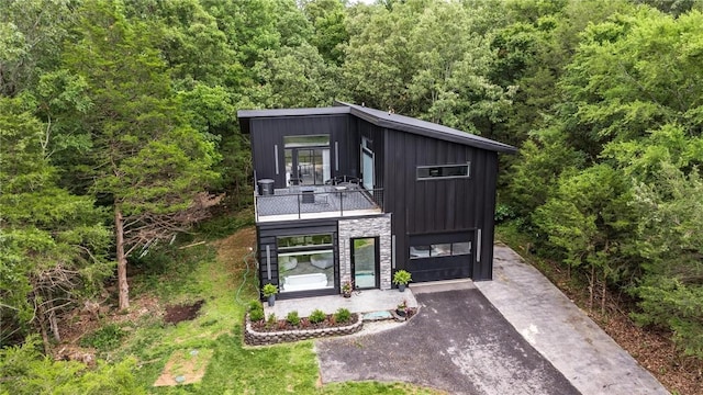 1630 Madison Unit 7855, Huntsville, AR 72740 - contemporary house with a balcony, board and batten siding, a wooded view, stone siding, and asphalt driveway