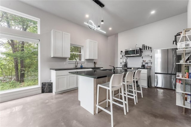 1630 Madison Unit 7855, Huntsville, AR 72740 - kitchen featuring appliances with stainless steel finishes, concrete flooring, dark countertops, open shelves, and recessed lighting