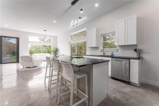 1630 Madison Unit 7855, Huntsville, AR 72740 - kitchen featuring dishwasher, finished concrete flooring, white cabinetry, dark countertops, and a kitchen breakfast bar