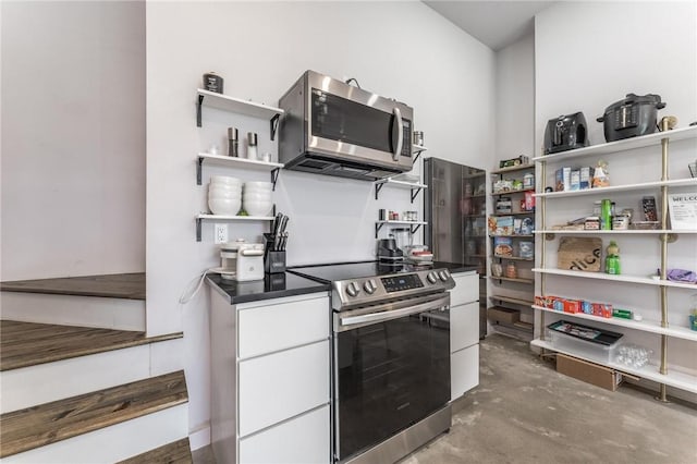 1630 Madison Unit 7855, Huntsville, AR 72740 - kitchen featuring open shelves, appliances with stainless steel finishes, white cabinetry, concrete flooring, and dark countertops