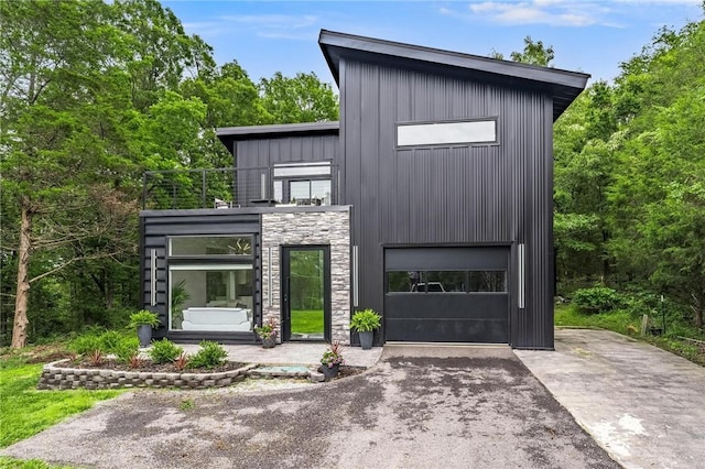 1630 Madison Unit 7855, Huntsville, AR 72740 - contemporary home featuring asphalt driveway, stone siding, board and batten siding, and an attached garage