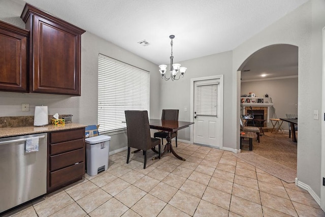 1902 SW Sequoia St, Bentonville, AR 72713 - dining room featuring light tile patterned floors, arched walkways, a chandelier, and a fireplace with raised hearth