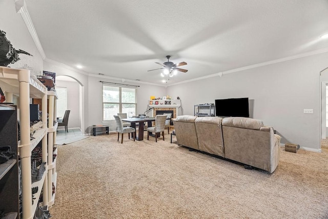 1902 SW Sequoia St, Bentonville, AR 72713 - carpeted living room with ornamental molding, a fireplace, ceiling fan, arched walkways, and recessed lighting