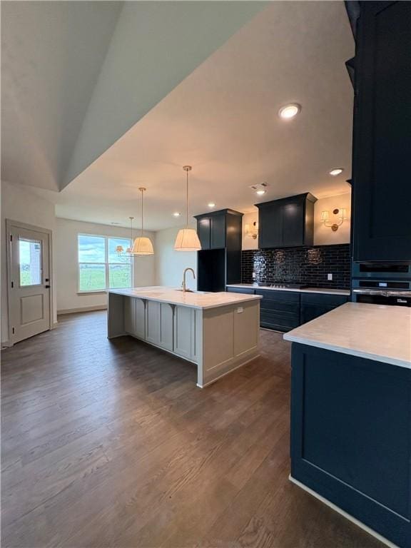825 Bellagiola, Tontitown, AR 72762 - kitchen featuring an island with sink, backsplash, dark wood-type flooring, light countertops, and recessed lighting