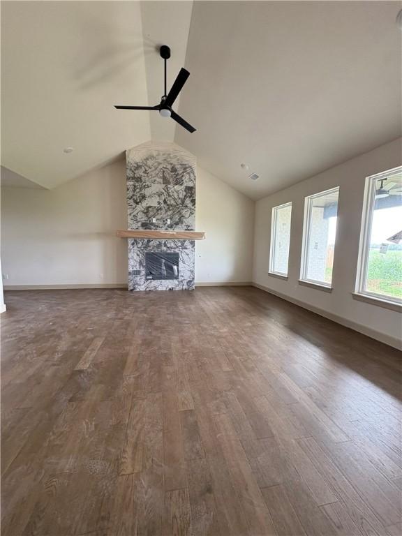 825 Bellagiola, Tontitown, AR 72762 - unfurnished living room featuring lofted ceiling, wood finished floors, ceiling fan, and a fireplace