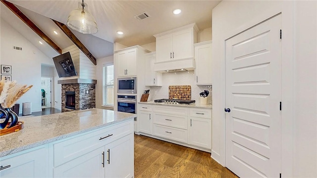 884 Ardiano Ave, Tontitown, AR 72762 - kitchen with stainless steel appliances, wood finished floors, a fireplace, light stone counters, and decorative backsplash