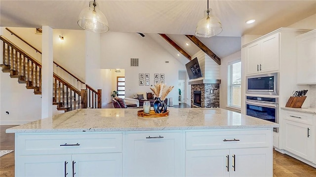 884 Ardiano Ave, Tontitown, AR 72762 - kitchen with appliances with stainless steel finishes, a fireplace, white cabinetry, a center island, and high vaulted ceiling