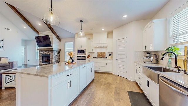 884 Ardiano Ave, Tontitown, AR 72762 - kitchen with stainless steel appliances, open floor plan, light wood finished floors, decorative backsplash, and light stone countertops