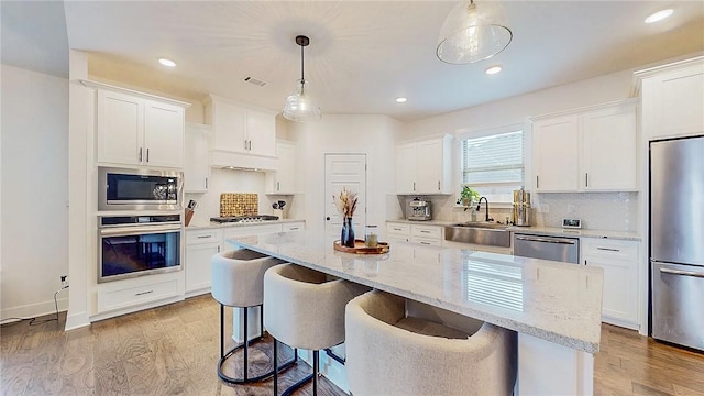 884 Ardiano Ave, Tontitown, AR 72762 - kitchen featuring stainless steel appliances, light wood finished floors, white cabinetry, a center island, and recessed lighting