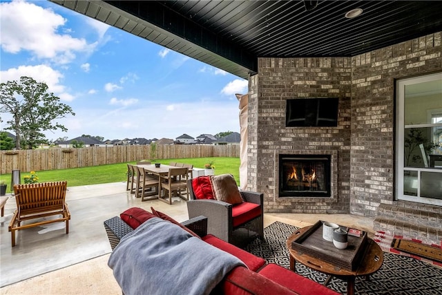 320 Bequette Ln, Centerton, AR 72719 - fenced backyard with outdoor dining space, a patio area, and an outdoor living space with a fireplace