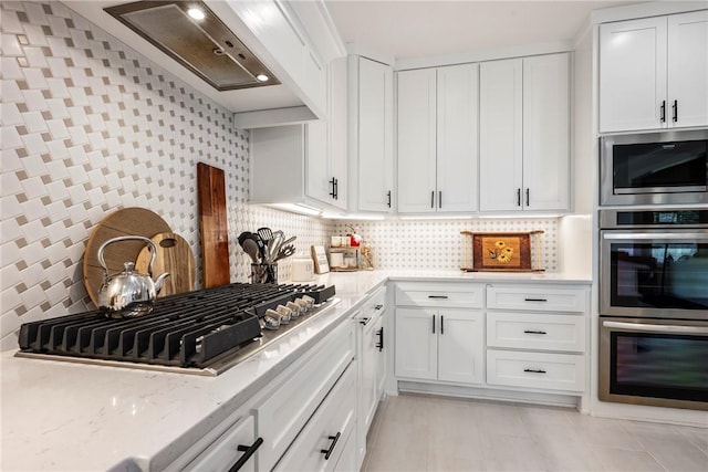 320 Bequette Ln, Centerton, AR 72719 - kitchen featuring stainless steel appliances, white cabinets, light stone counters, light tile patterned flooring, and decorative backsplash