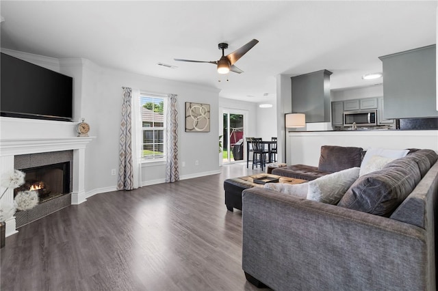 874 Oakwood Ln, Centerton, AR 72719 - living room with ceiling fan, dark wood finished floors, and a lit fireplace